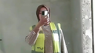 Turkish girl with headscarf who turns on the camera and puts on a show at the construction site