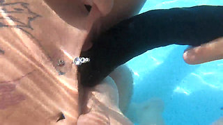Camilla and Cheyenne Play with a double ended dildo in the pool