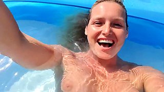 Milf seductress fingering her shaved pussy in the pool