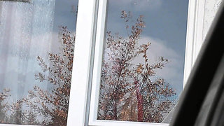 Naked in public. Taxi driver watches from car as woman in robe without panties and bra in stockings washes an apartment window